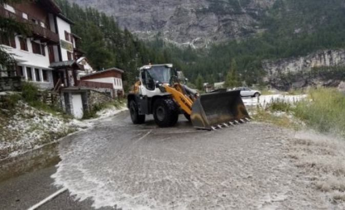 Una ruspa al lavoro nel vano tentativo di liberare la strada dalla grandine e dal fango (foto AP)